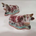 A pair of Delft models of cows, recumbent on shape