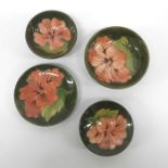 Four Walter Moorcroft hibiscus on green pin dishes