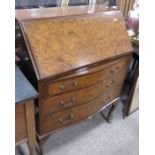 A 1920s burr walnut veneered fall front bureau chest