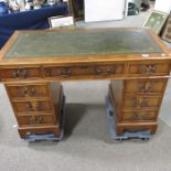 A Yew wood pedestal desk, leather inset top with t