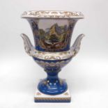 A Continental porcelain twin handled pedestal vase