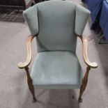 An Arts and Crafts style beech and upholstered wing back open armchair