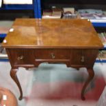 A walnut veneered lowboy, circa 1910, fitted thre