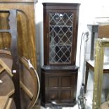 A corner cupboard, with leaded glass door above fo