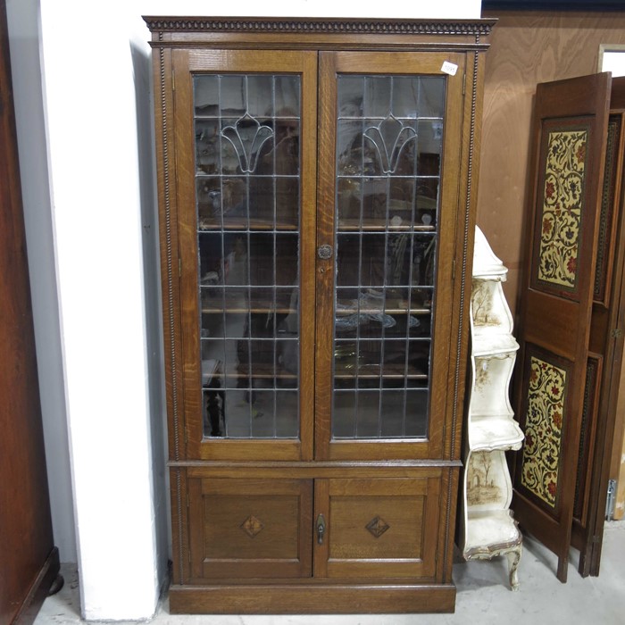 A 1920s oak and lead glazed bookcase cabinet, with