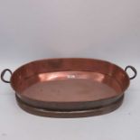 A copper and brass oval twin handled roasting pan.