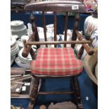 An antique child's rocking chair with safety bar