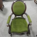 A Victorian carved walnut and upholstered oval back open armchair