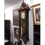 A Vienna mahogany cased wall clock, mask carved pe