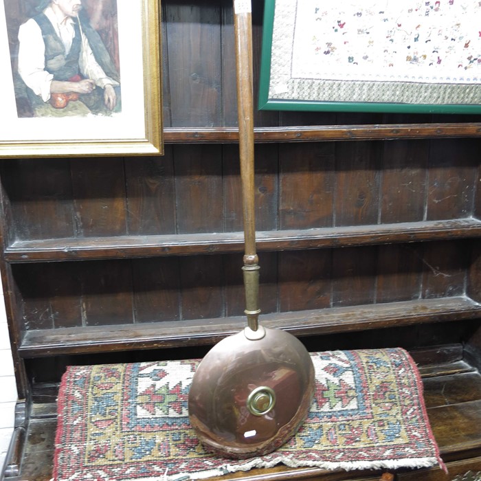 A copper and brass warming pan with oak turned han