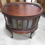 A stained wood oval glazed cabinet with tray top