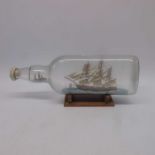 A Ship in a bottle, 'The Cutty Sark, on wooden sta