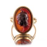 A Revivalist yellow metal and carved carnelian ring, in the style of Castellani