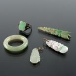 Three Chinese carved jade pendants, together with a silver and marcasite jade ring and a carved ring