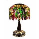 A bronze and stained glass table lamp, in the style of Tiffany