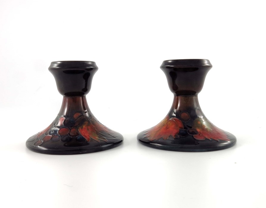 William Moorcroft, a pair of Flambe Leaf and Berry candlesticks