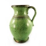 A 19th century green glazed earthenware jug