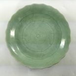 A Chinese celadon glaze circular plate, Qianlong seal mark and of the period, sgraffito decoration