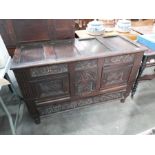 A 17th century style carved oak and panel two door cupboard, with lift up top and drawer, 124cm wide