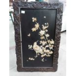 A Japanese black lacquered shibayama bone and mother of pearl panel in carved frame, 75cm x 42cm