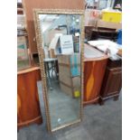 A gilt framed bevel plate glass dressing mirror, 127cm x 46cm