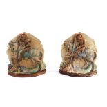 A pair of Compton Pottery bookends, moulded image of St George & Dragon, pastel coloured on shield