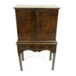 An early 18th Century walnut oyster veneered cabinet on stand, probably continental, crossbanded top