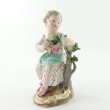A Meissen figurine of a woman seated beside a tree stump with a garland of flowers, 20th Century,