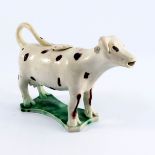 An English pottery cow creamer, Staffordshire or Yorkshire, circa 1815, spotted decoration on a