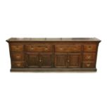 A George III country oak dresser base, circa 1770, four frieze drawers over twin panelled central
