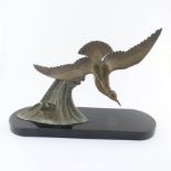 After Dautrive, an Art Deco bronze stylized figure of a seagull in flight over a wave, signed