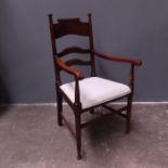 An Arts & Crafts armchair in the manner of William Birch, early 20th Century, extended uprights with