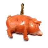 A mid to late 19th century carved coral pig charm pendant, with gold mount