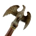 A bronzed metal eagle finial topper, mounted on part of staff, eagle 15cm high