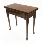 A George III mahogany tea table, circa 1790, fold-over top, single frieze drawer, gateleg action,