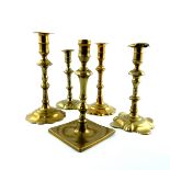 Five assorted mid 18th Century brass socket candlesticks, all with knopped stems, four with dished