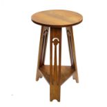 An Arts & Crafts light oak occasional table, circa 1905, circular top, triple outswept fretwork legs