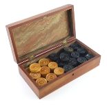 A double set of Victorian draughts pieces, natural and ebonised boxwood, in two sizes, within a