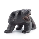 A late 19th Century Black Forest decorative model of a carved wooden bear, in prowling pose with