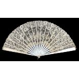 A large Brussels Mixed lace fan c 1890’s, the leaf mounted on white Mother of Pearl, with bone ribs,