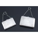 Two hallmarked silver purses with short chains and finger rings, both classically engraved and beari