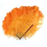 A large and showy asymmetrical tangerine feather fan, shaded to orange at the tips, early 20th cent