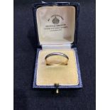 A mid 20th century white and yellow metal wedding band ring