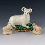A Staffordshire pottery ram and two white glazed m