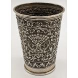 An early 20th century Indonesian silver beaker, chased with scrolling floral and fauna designs,