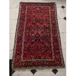 An Afghan red ground rug/carpet, 213cm x 124cm