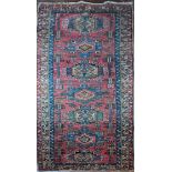 An Afghan red and navy ground runner carpet, 135cm x 93cm