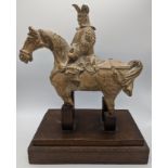 An early Chinese terracotta horseback rider, mounted on wooden base, H.28cm (including base)