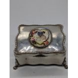 A silver jewellery box mounted with an enamel portrait of a pug dog, raised on 4 paw feet,