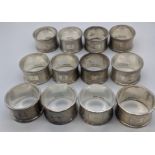 A set of 12 silver napkins rings, engine turned outers, hallmarked Birmingham, 1957, maker C&N,